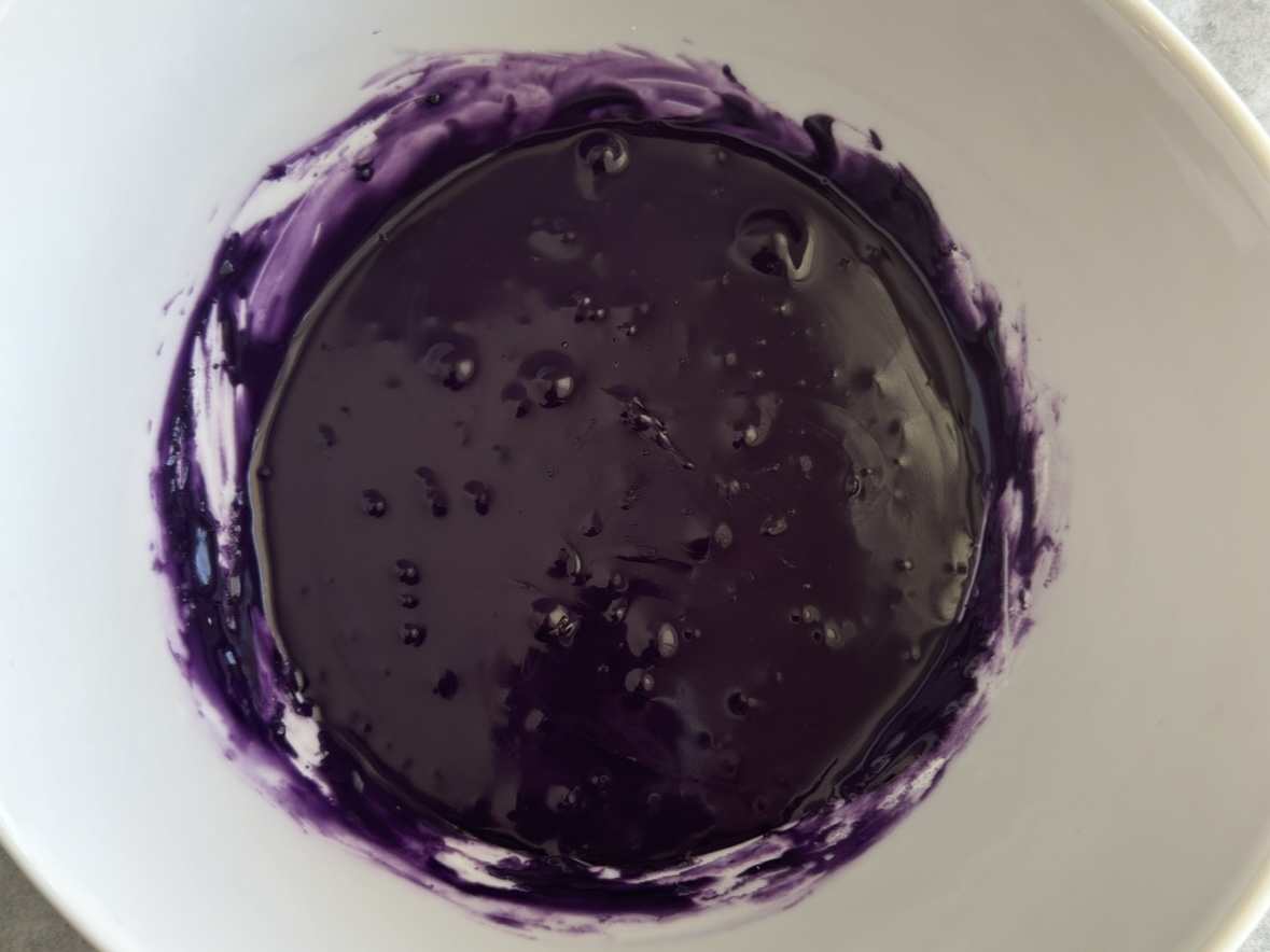 Ube icing mixed in a bowl