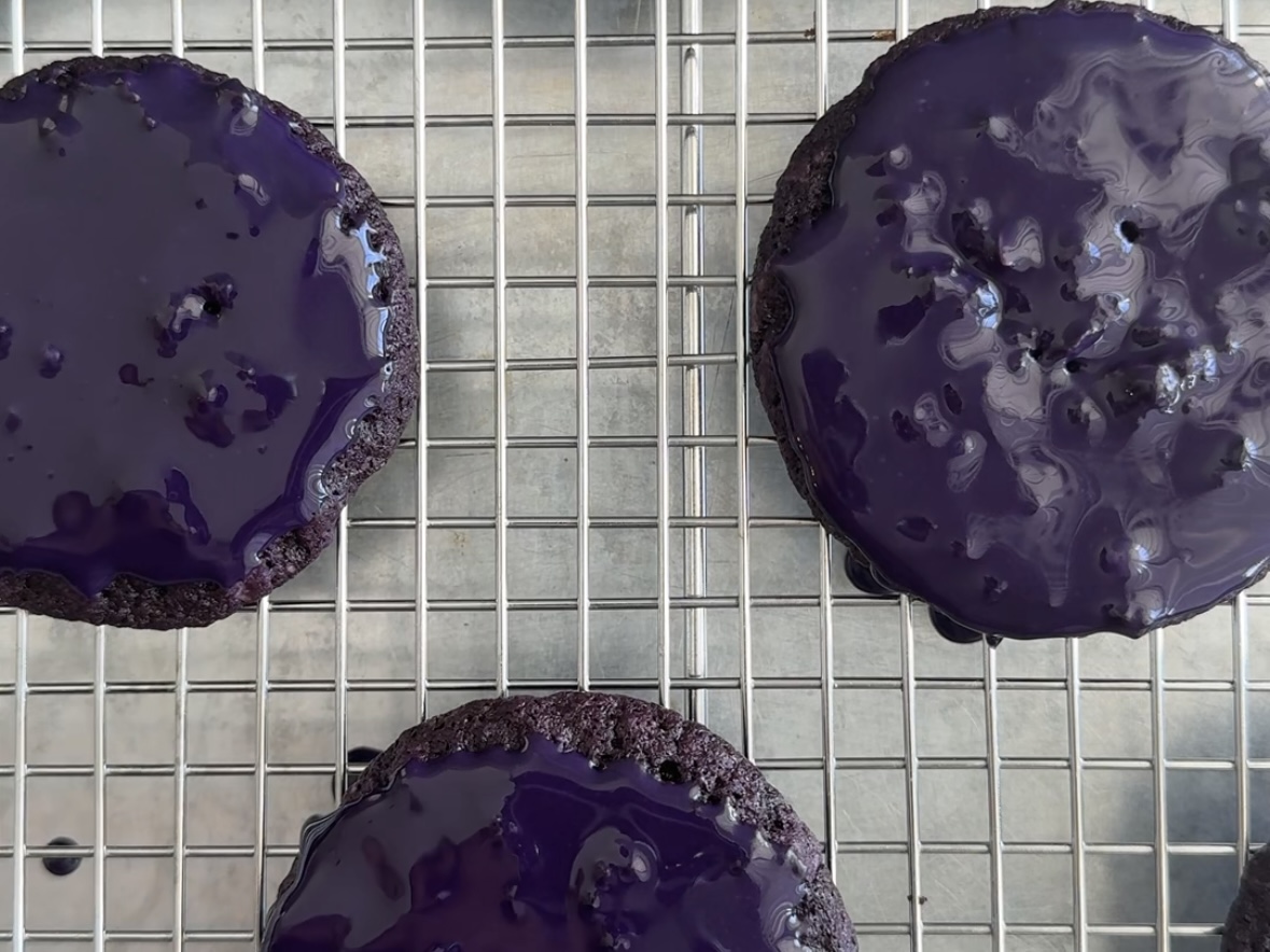 Ube iced oatmeal cooking freshly dipping in icing on a cooling rack