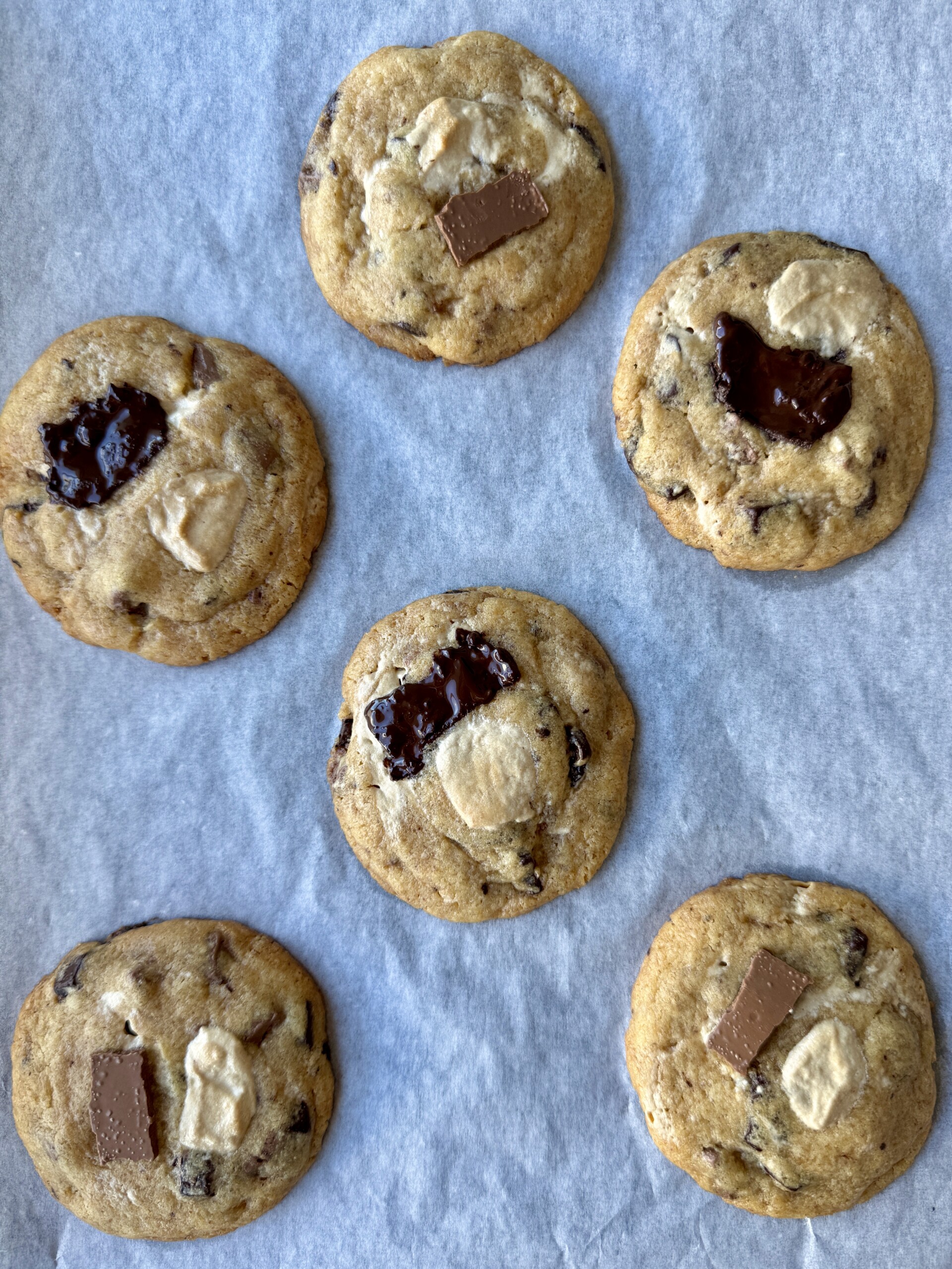 Brown butter halva chocolate chunk cookies baked and on parchment paper