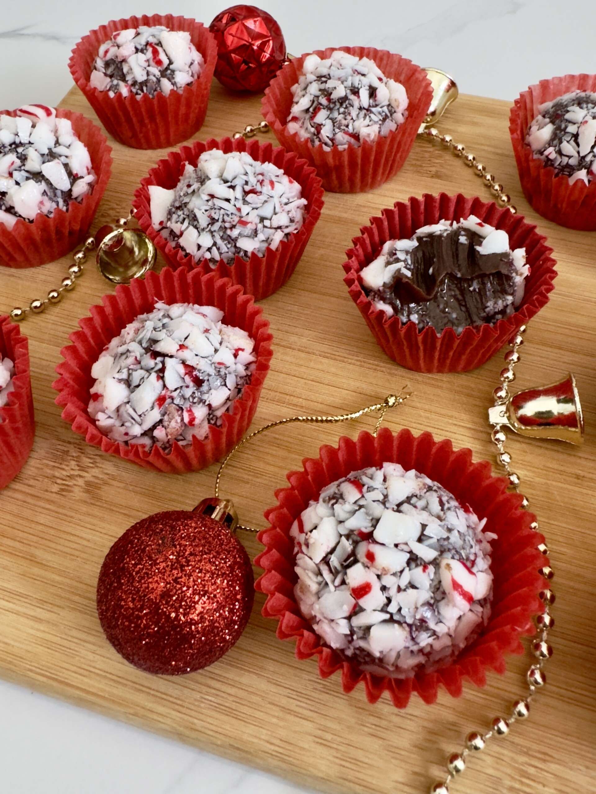 Peppermint brigradeiros in red candy cups with holiday ornaments