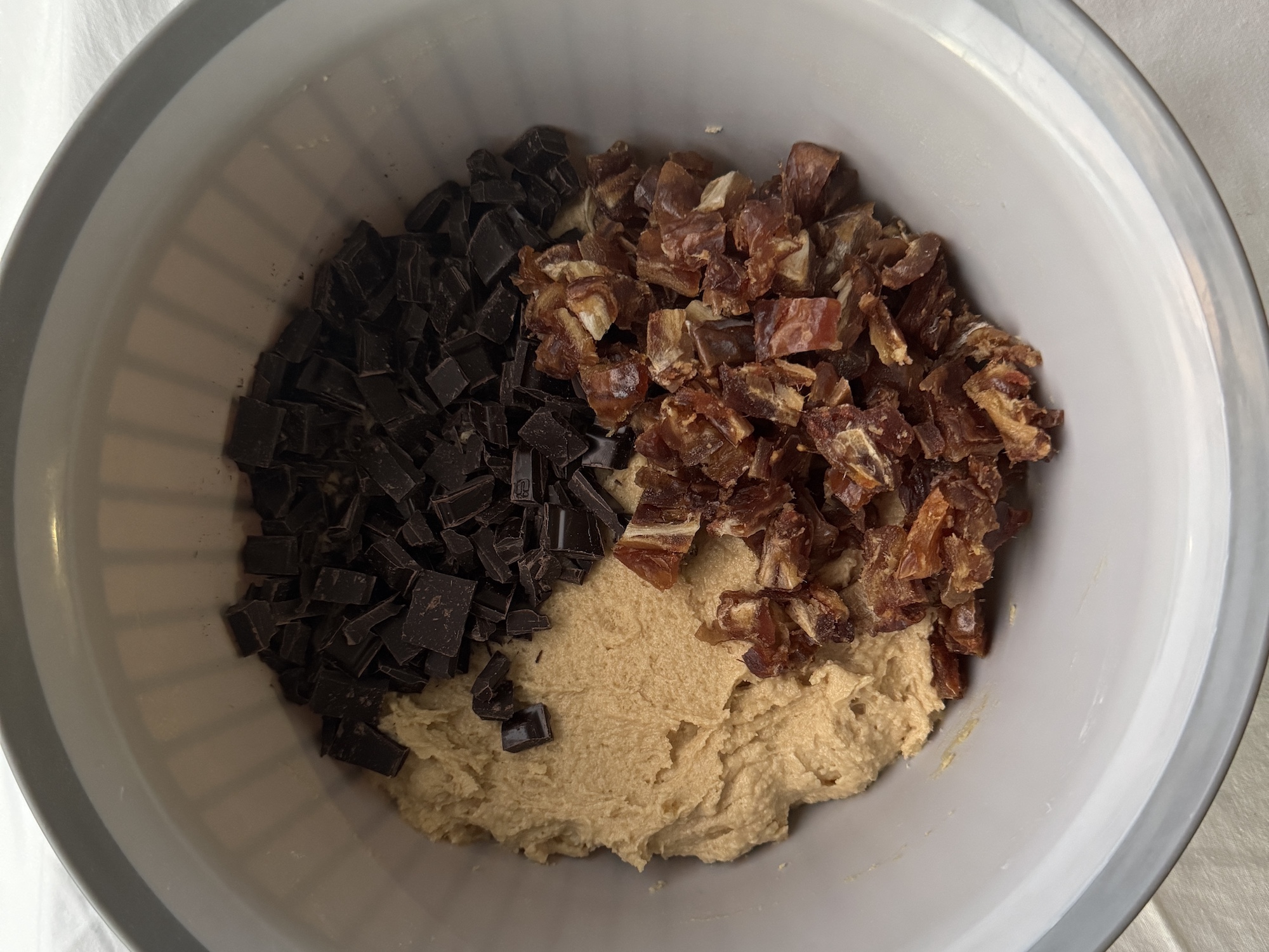 Chopped chocolate and Medjool dates in a bowl ready to mix in to cookie dough