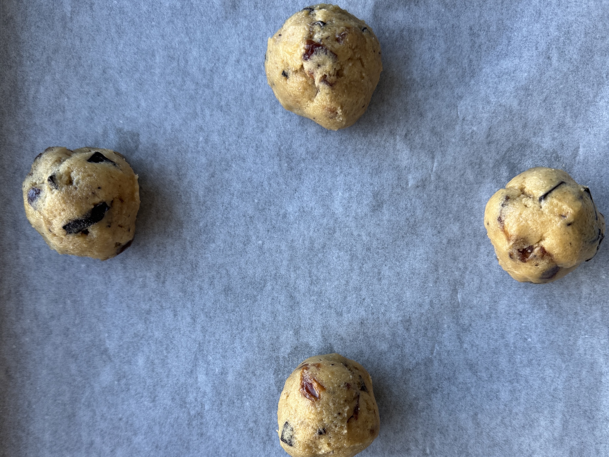 Tahini date chocolate chunk cookie dough balls on parchment paper