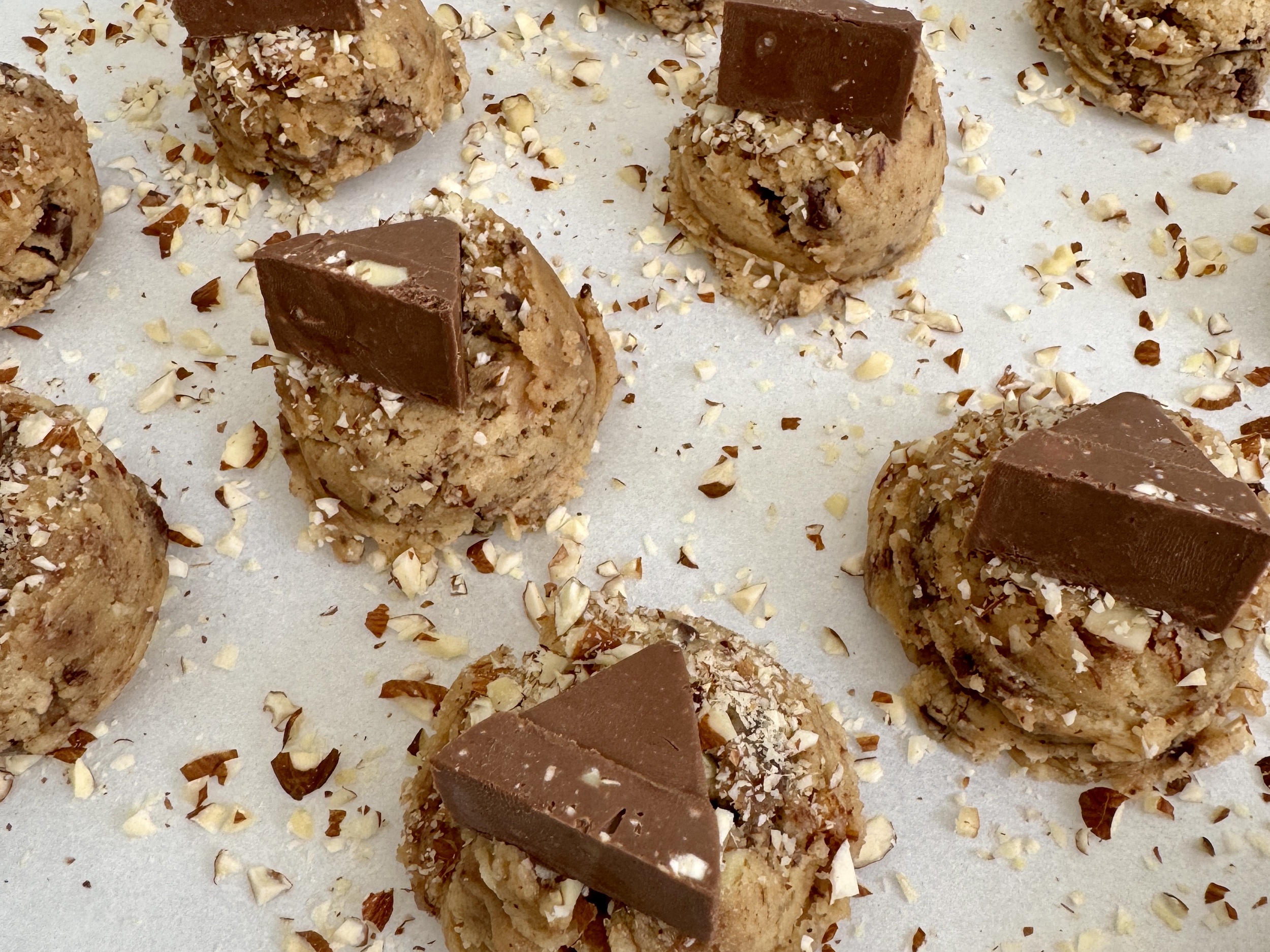 Brown Butter Almond Honey Toblerone Cookies scooped and topped with almonds and Toblerone