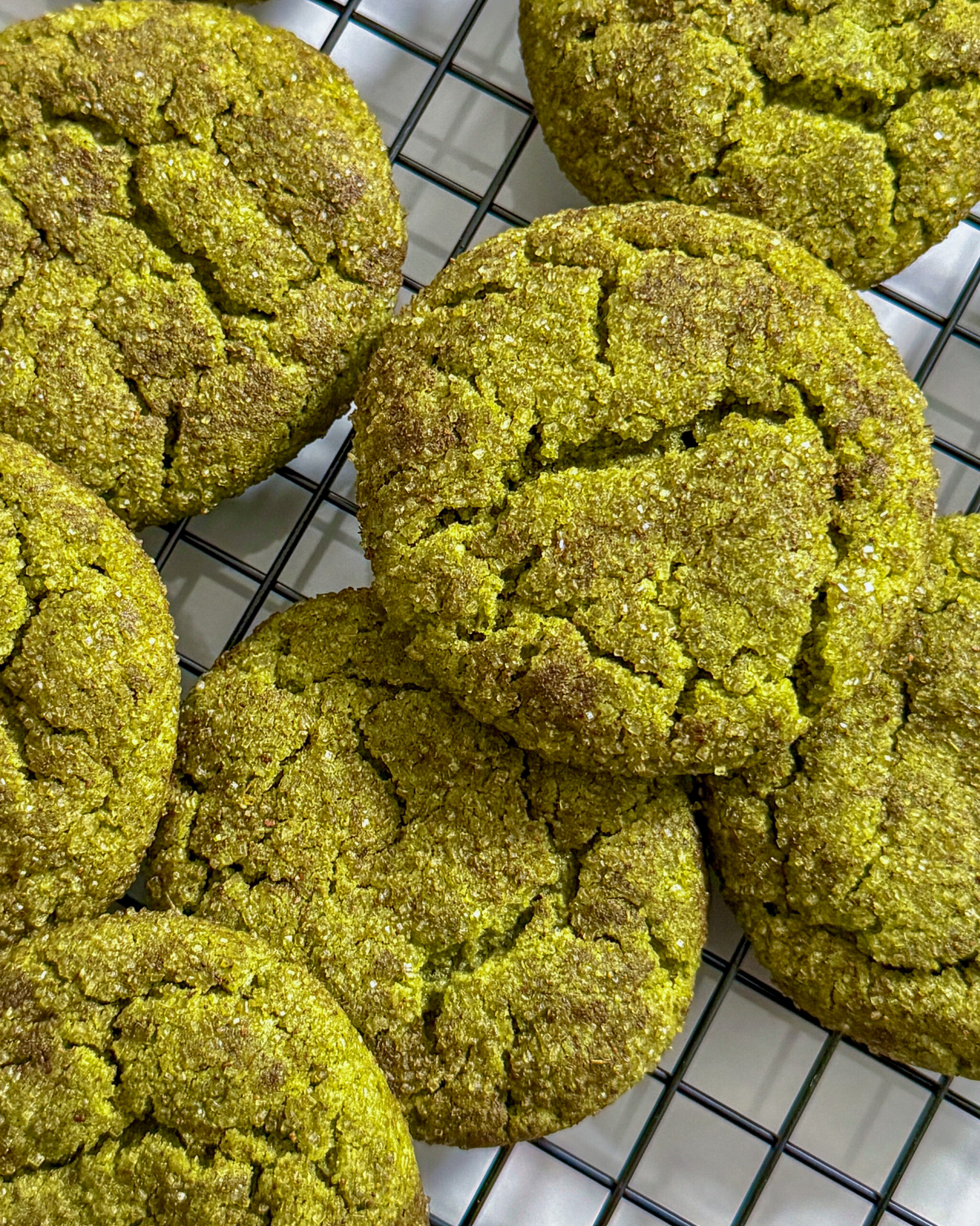 Matcha snickerdoodle cookies overlapping on each other on wire cooling rack